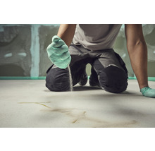 Handwerker trägt Estrich auf dem Boden auf