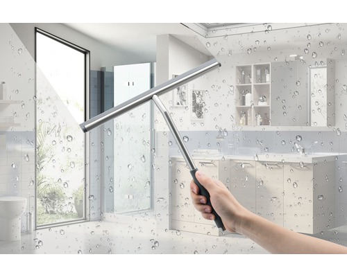 Hand mit Fensterabzieher vor Badezimmerfliesen