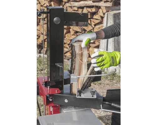 Eine Person spaltet Holz mit einem Holzspalter.