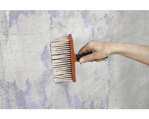 Tapezierbürste im Einsatz auf einer Wand.