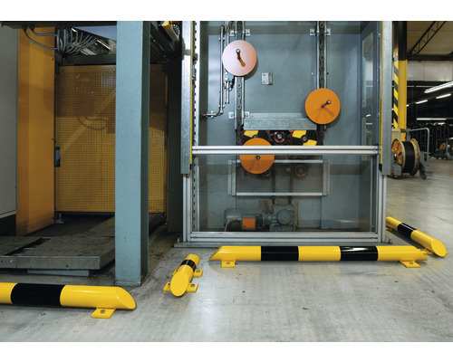 Gelb-schwarze Anfahrschutzprofile vor einer Produktionsmaschine.