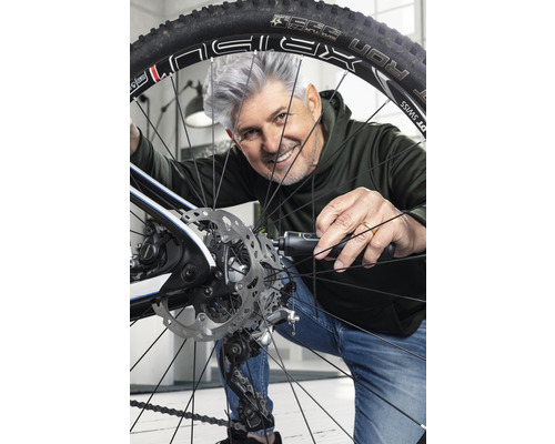 Mann repariert Fahrradreifen mit Werkzeug