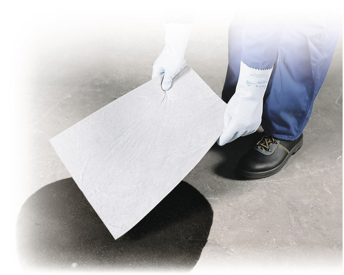 Eine Person mit Handschuhen hält ein Ölabsorptionspad über einen Ölfleck.