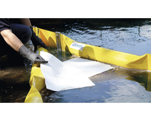 Person mit Handschuhen, die Ölsperre und Absorptionsmittel im Wasser platziert