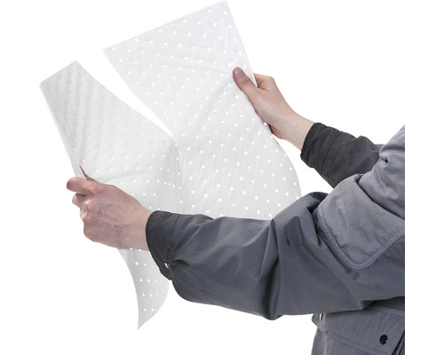 Person hält perforierte Ölbindevlies-Zuschnitte in den Händen.