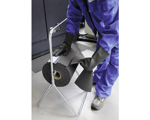 Eine Person verwendet eine Absorberrolle mit einem Metallständer zum Aufsaugen von Flüssigkeiten.