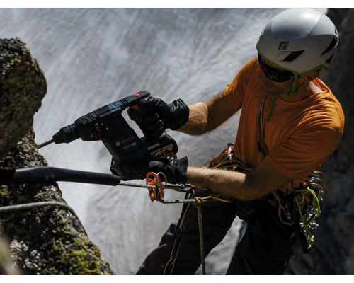 Handwerker bohrt mit einem Bohrhammer von Bosch ein Loch in einen Felsen.