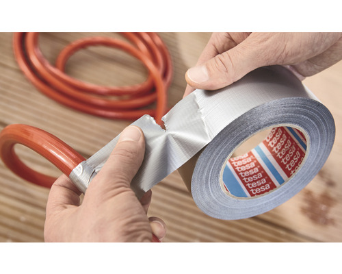 Eine Rolle Gewebeband der Marke Tesa wird verwendet, um einen Schlauch zu reparieren.