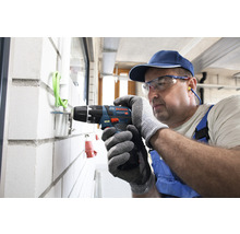 Handwerker bohrt mit einem Akku-Bohrschrauber in eine Wand