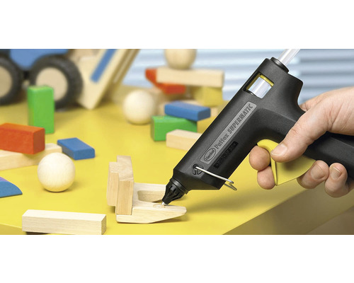 Heißklebepistole beim Verkleben von Holzbausteinen