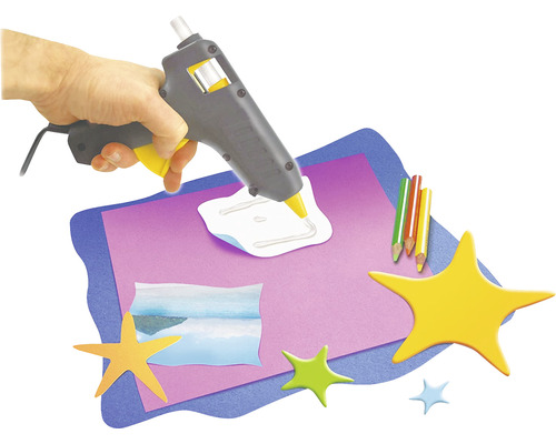 Heißklebepistole im Einsatz mit Papier und Sternen für Bastelarbeiten