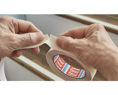 Doppelseitiges Tesa Klebeband wird von zwei Händen gehalten