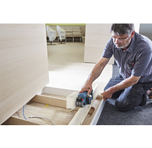 Handwerker hobelt Holz mit einem Elektrohobel
