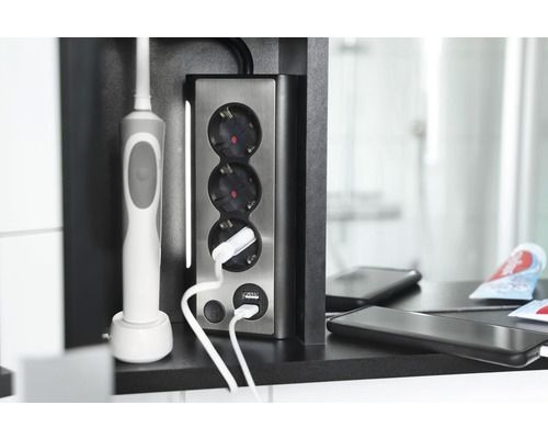 Einbausteckdose mit drei Steckplätzen und USB-Anschlüssen im Badezimmer mit eingestecktem Ladegerät