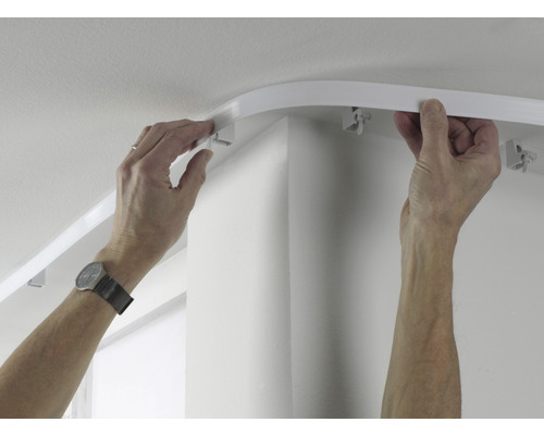 Person montiert eine Gardinenschiene an der Decke