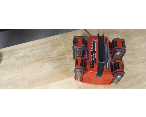 Einhell Power X-Change Akku-Ladegerät mit vier Akkus auf einem Tisch