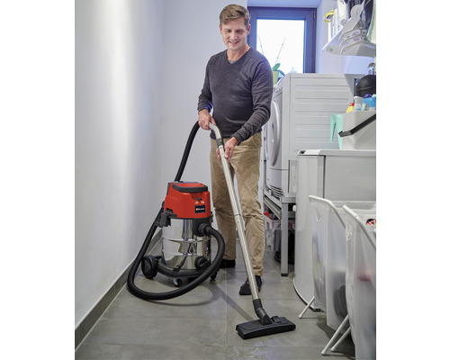 Ein Mann benutzt einen Nass Trockensauger in einem Hauswirtschaftsraum.