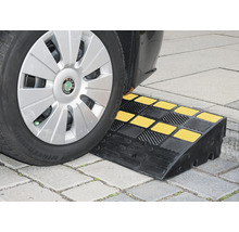 Auto fährt über eine Bordsteinrampe aus Gummi mit gelben Markierungen
