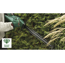 Eine Person bedient eine Heckenschere beim Schneiden einer Hecke. Im Vordergrund befindet sich das Ground Blades Symbol.