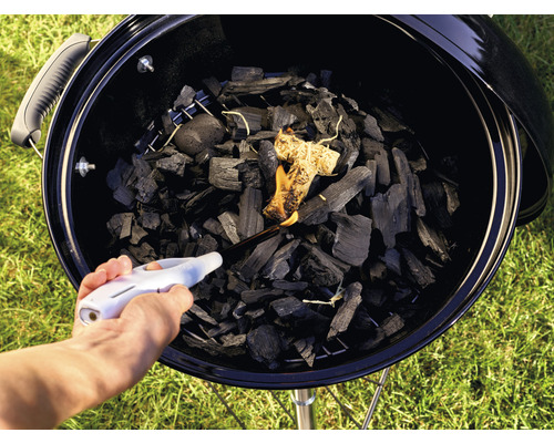 Anzünden von Holzkohle in einem Grill mit einem Feuerzeug