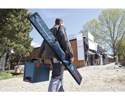 Handwerker mit Werkzeugkoffer und Tragetasche für Präzisions-Holzbearbeitungssystem auf einer Baustelle