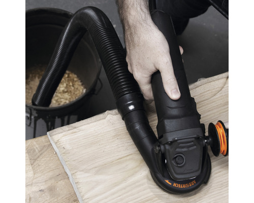Eine Person schleift ein Holzstück mit einem Schleifgerät mit Staubabsaugung.