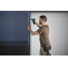 Ein Mann montiert eine Küchenfront mit einem Akkuschrauber.