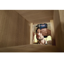 Handwerker schraubt Schraube mit Akku-Bohrschrauber in Holzkonstruktion