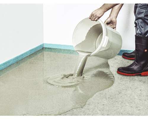 Eine Person gießt Ausgleichsmasse aus einem Eimer auf einen Boden.