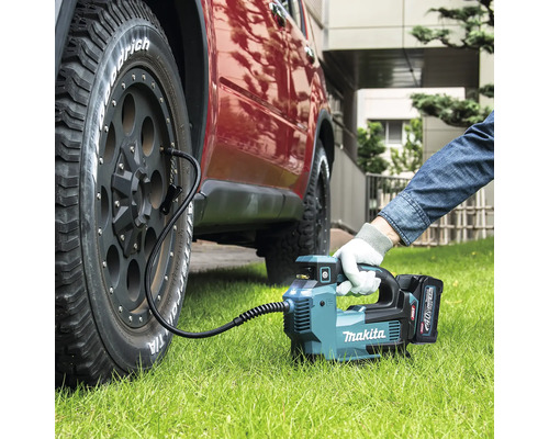 Makita Akku-Luftpumpe pumpt Autoreifen auf Rasen auf