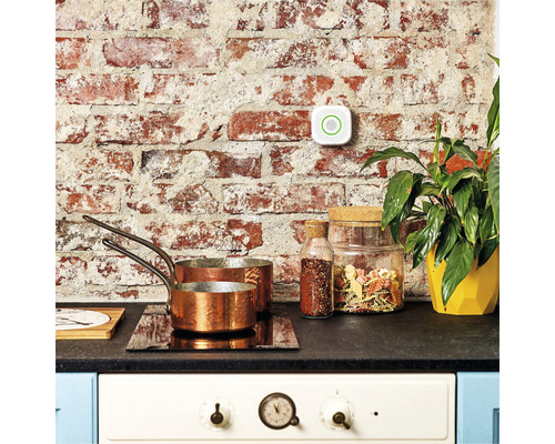 Szene einer Küche mit Herd, Töpfen, Vorratsgläsern und einem Rauchmelder an der Wand