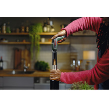 Szene einer Person, die mit einem elektrischen Korkenzieher eine Weinflasche öffnet. Bosch Logo.