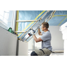 Dachausbau mit Trockenbauplatten, Holzkonstruktion und Handwerker mit Akkuschrauber