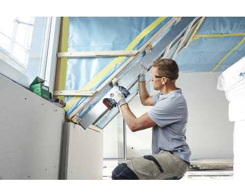 Dachausbau mit Trockenbauplatten, Holzkonstruktion und Handwerker mit Akkuschrauber