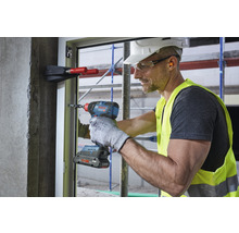 Handwerker mit Akku-Schlagschrauber bei der Fensterinstallation.