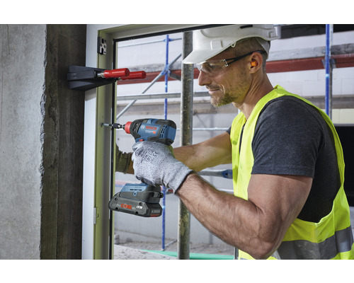 Handwerker mit Akku-Schlagschrauber bei der Fensterinstallation.