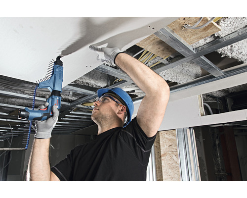 Ein Mann befestigt eine Deckenplatte mit einem Magazinschrauber