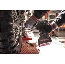 Ein Mechaniker verwendet einen Akku-Schlagschrauber, um an einem Motorradrad zu arbeiten.