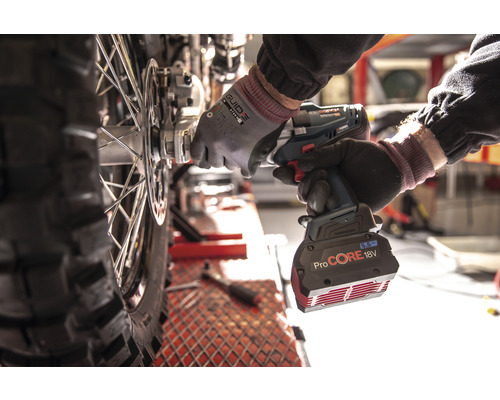 Ein Mechaniker verwendet einen Akku-Schlagschrauber, um an einem Motorradrad zu arbeiten.