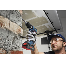 Akkuschrauber im Einsatz an einer Ziegelwand