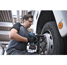 Ein Mann benutzt einen Akku-Schlagschrauber, um ein Rad an einem Fahrzeug zu befestigen.