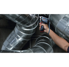 Ein Akku-Schlagschrauber bohrt in ein Lüftungsrohr. Bosch Logo.