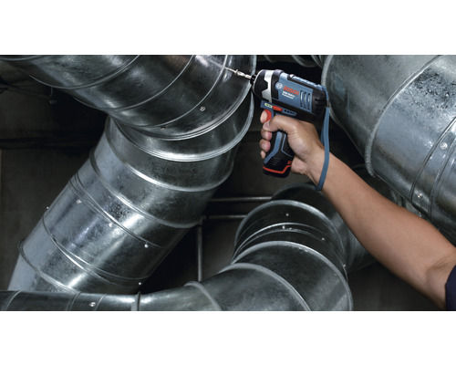 Ein Akku-Schlagschrauber bohrt in ein Lüftungsrohr. Bosch Logo.