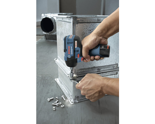 Eine Person befestigt mit einem Akku-Schlagschrauber Metallteile. Schrauben und Muttern liegen daneben.