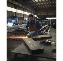 Ein Arbeiter schleift Metall mit einem Winkelschleifer in einer Werkstatt.