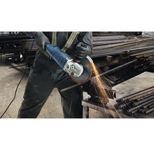 Mann schneidet Bewehrungsstahl mit einem Winkelschleifer, wobei Funken entstehen