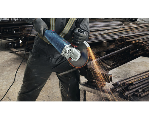 Mann schneidet Bewehrungsstahl mit einem Winkelschleifer, wobei Funken entstehen