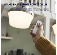 Hand mit Fernbedienung unter einer Deckenleuchte