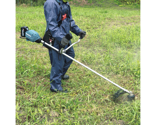 Person bedient einen Akku-Rasentrimmer im Garten.