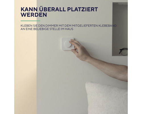 Person bedient einen Dimmschalter an einer Wand